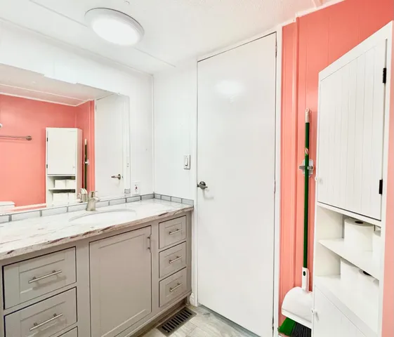 a bathroom with a granite countertop sink and a mirror