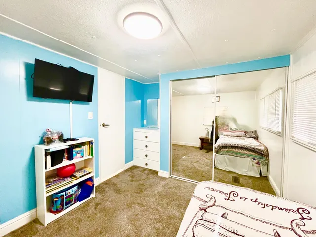 a bedroom with furniture and a flat screen tv