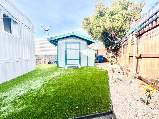 a view of a house with backyard and a tree