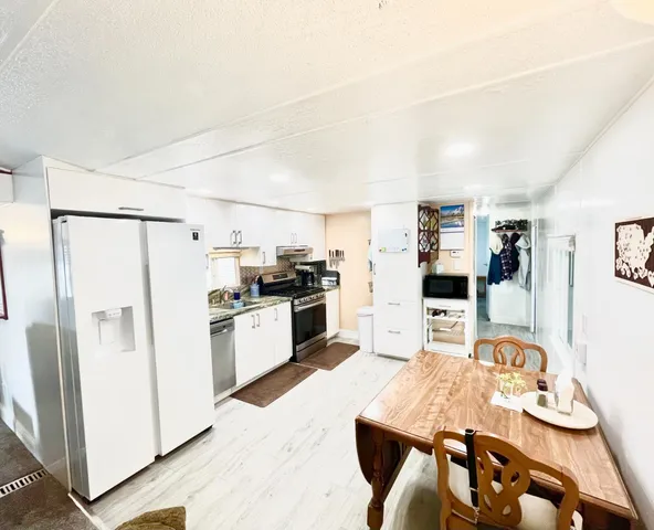 a kitchen with stainless steel appliances granite countertop a refrigerator and a stove top oven