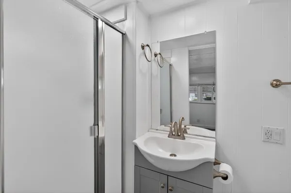 a bathroom with a granite countertop sink shower and a mirror