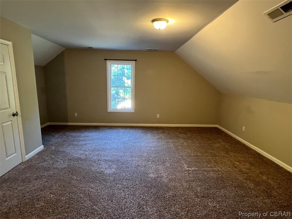 108 Hill Crest Road Wake, VA 23176 - Photo 13 of 21 Additional living space featuring vaulted ceiling and dark colored carpet
