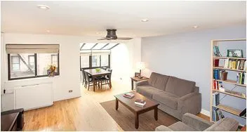a living room with furniture and a book shelf