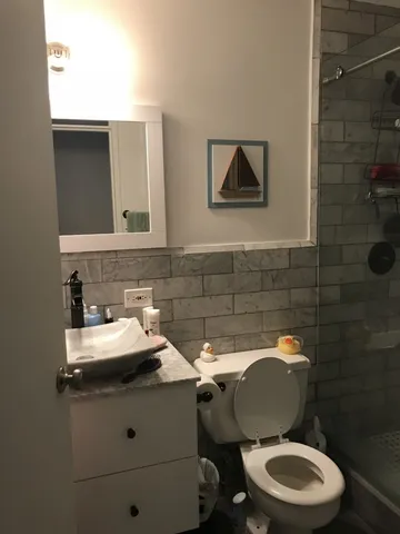 a bathroom with a toilet sink and mirror