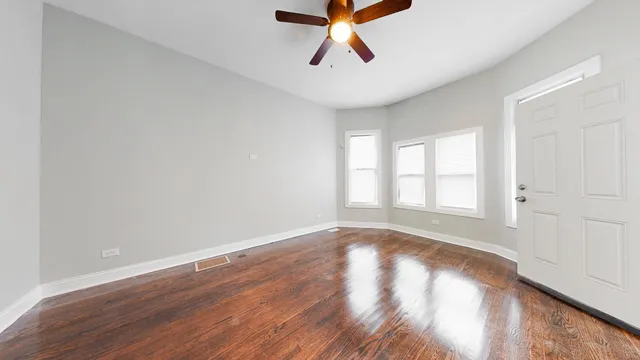 a view of empty room with wooden floor and window