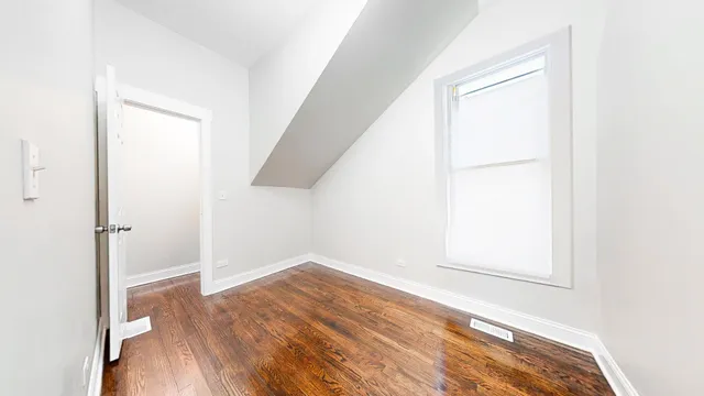 an empty room with wooden floor and closet