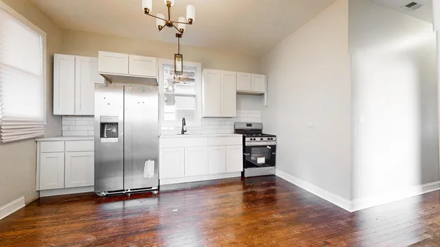 a kitchen with stainless steel appliances a refrigerator and a stove top oven