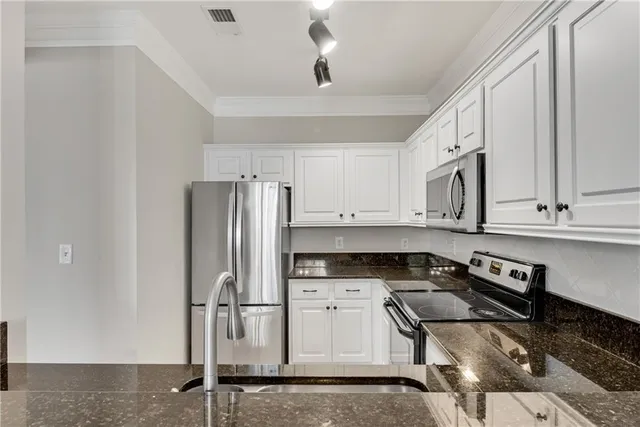 a kitchen with stainless steel appliances granite countertop a refrigerator sink and stove