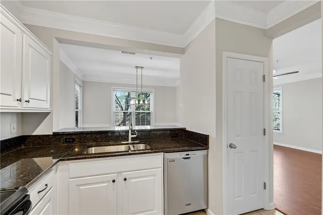 a kitchen with granite countertop a sink and cabinets