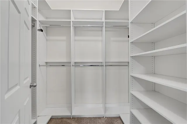 a view of walk in closet with empty racks