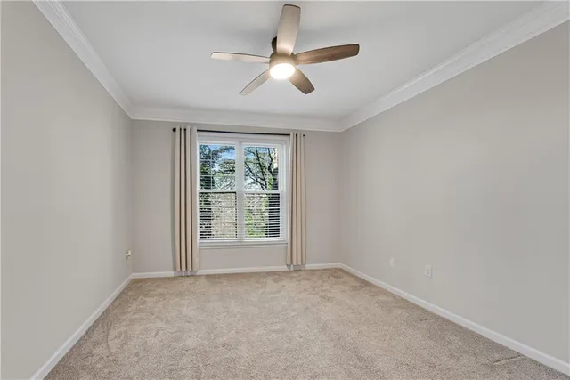 an empty room with a ceiling fan and windows