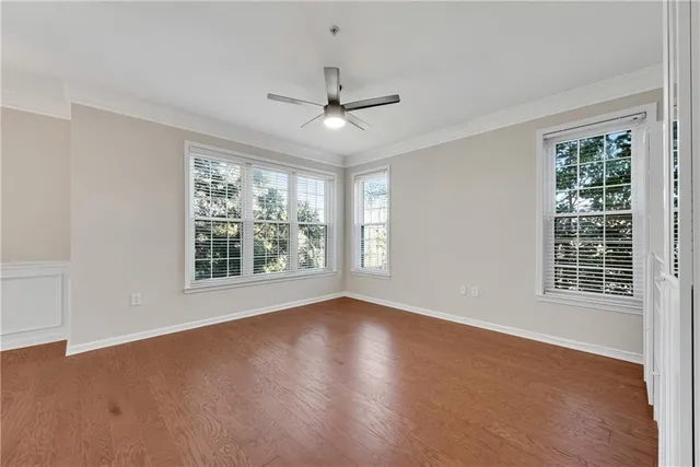 a view of an empty room with a window and wooden floor