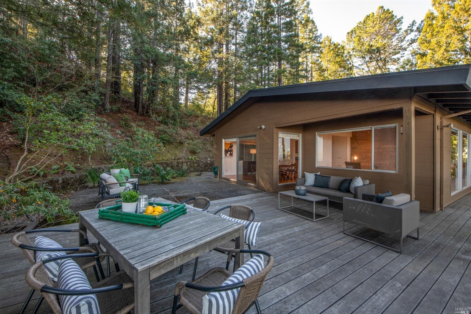 a view of a patio with table and chairs with wooden floor and fence