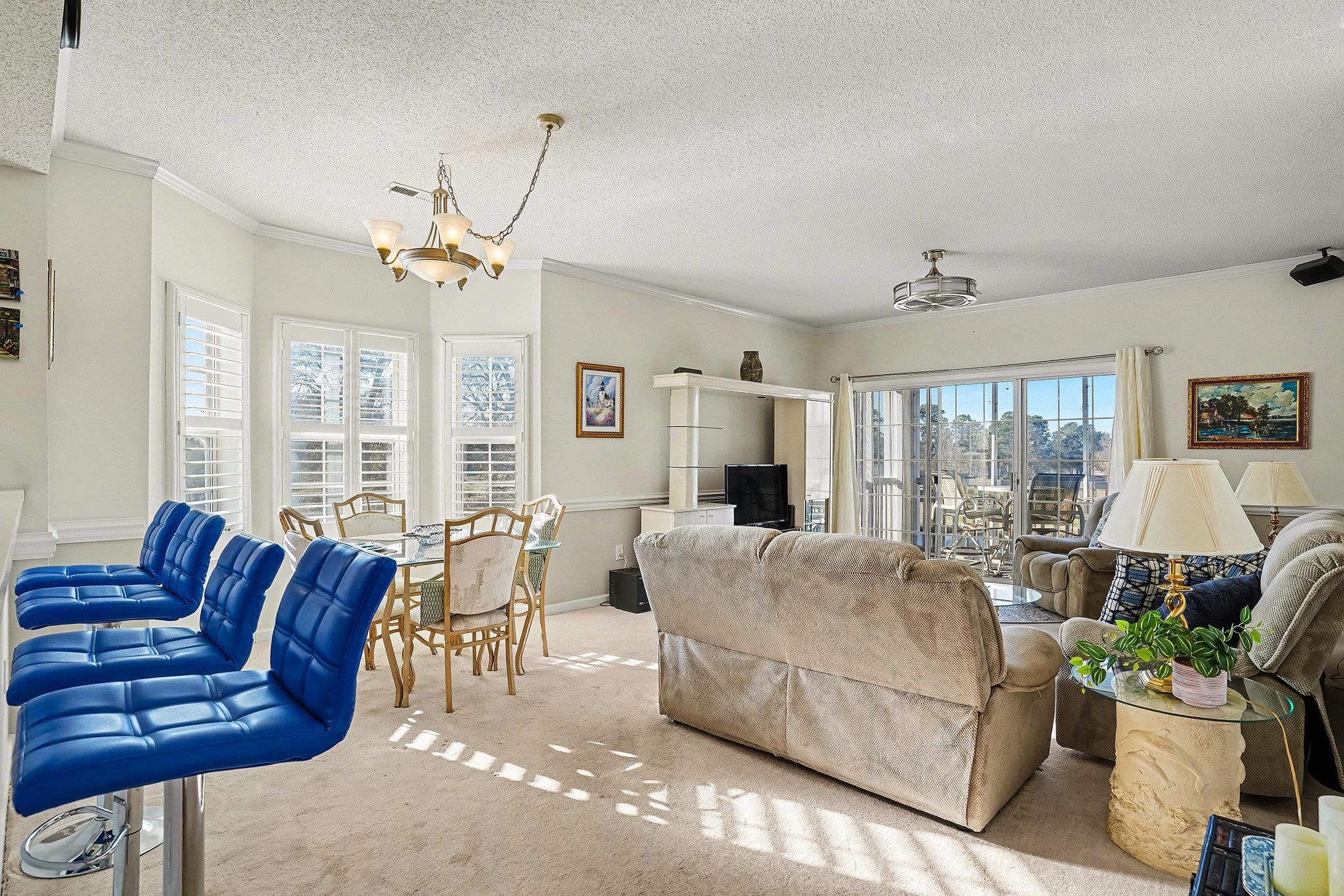 4429 Turtle Lane, Unit 3A Little River, SC 29566 - Photo 12 of 31 Living room with a chandelier, carpet, ornamental molding, and a textured ceiling