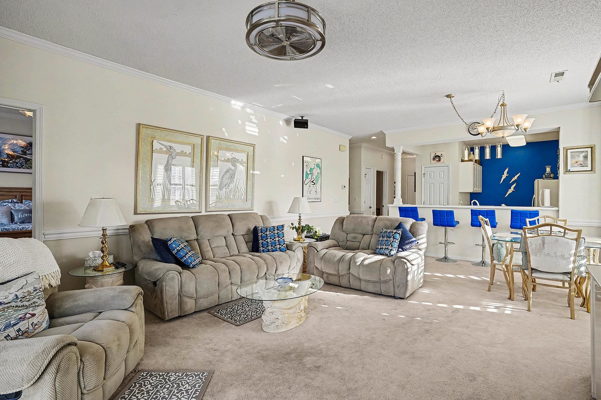 4429 Turtle Lane, Unit 3A Little River, SC 29566 - Photo 7 of 31 Living room featuring crown molding, a textured ceiling, a chandelier, and carpet