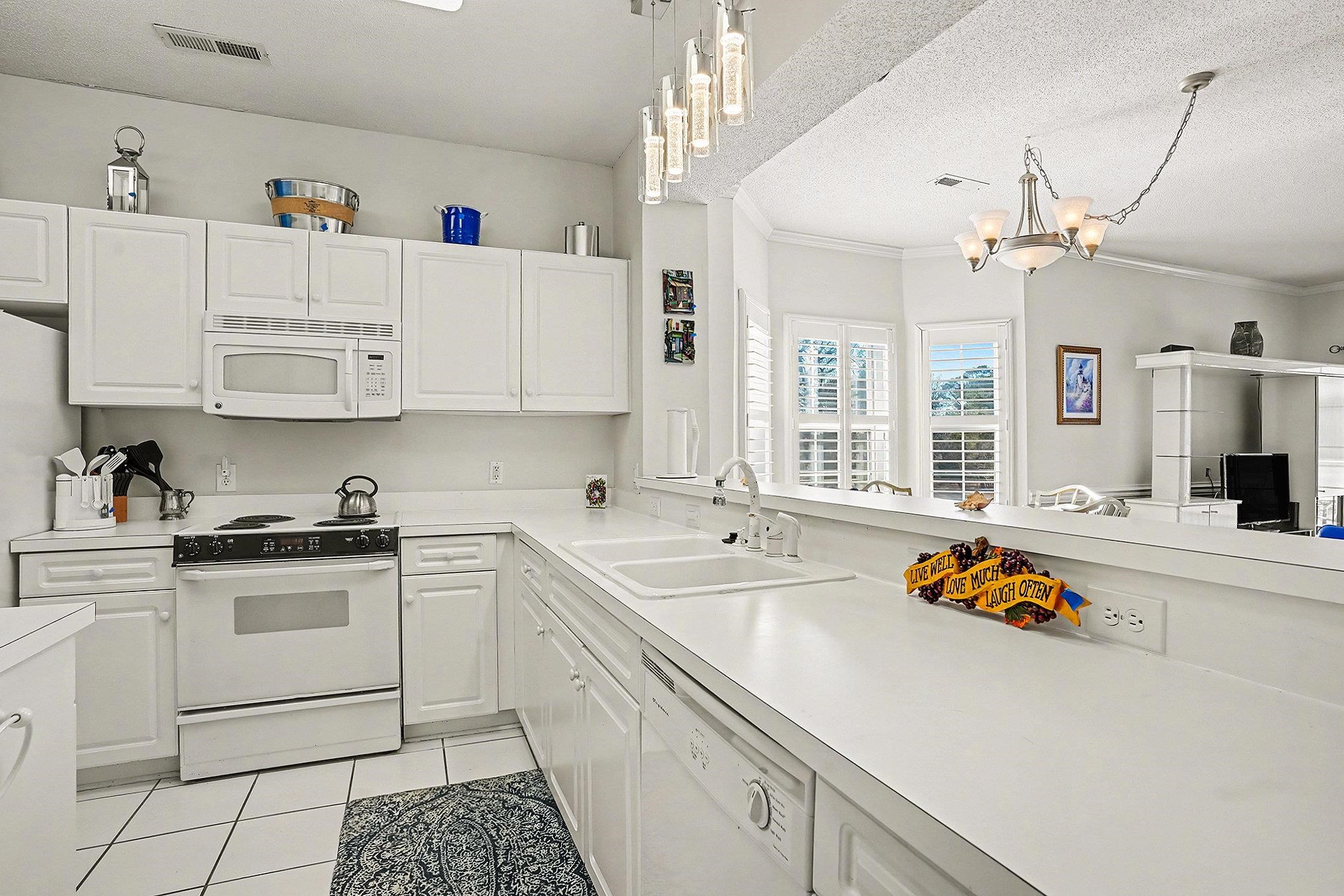 4429 Turtle Lane, Unit 3A Little River, SC 29566 - Photo 9 of 31 Kitchen featuring white appliances, white cabinets, light countertops, a textured ceiling, and crown molding