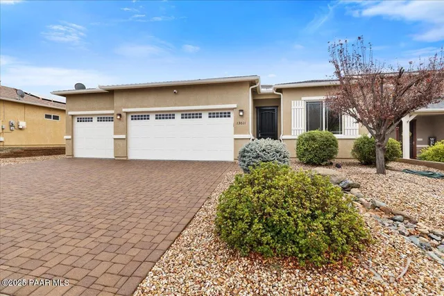 a view of a house with a yard and potted plants