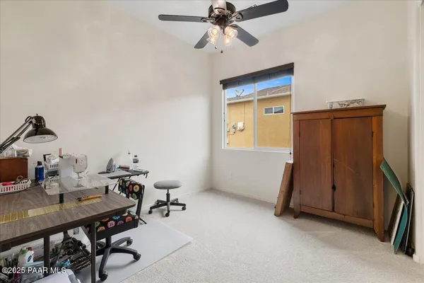 a view of a workspace with furniture and a window
