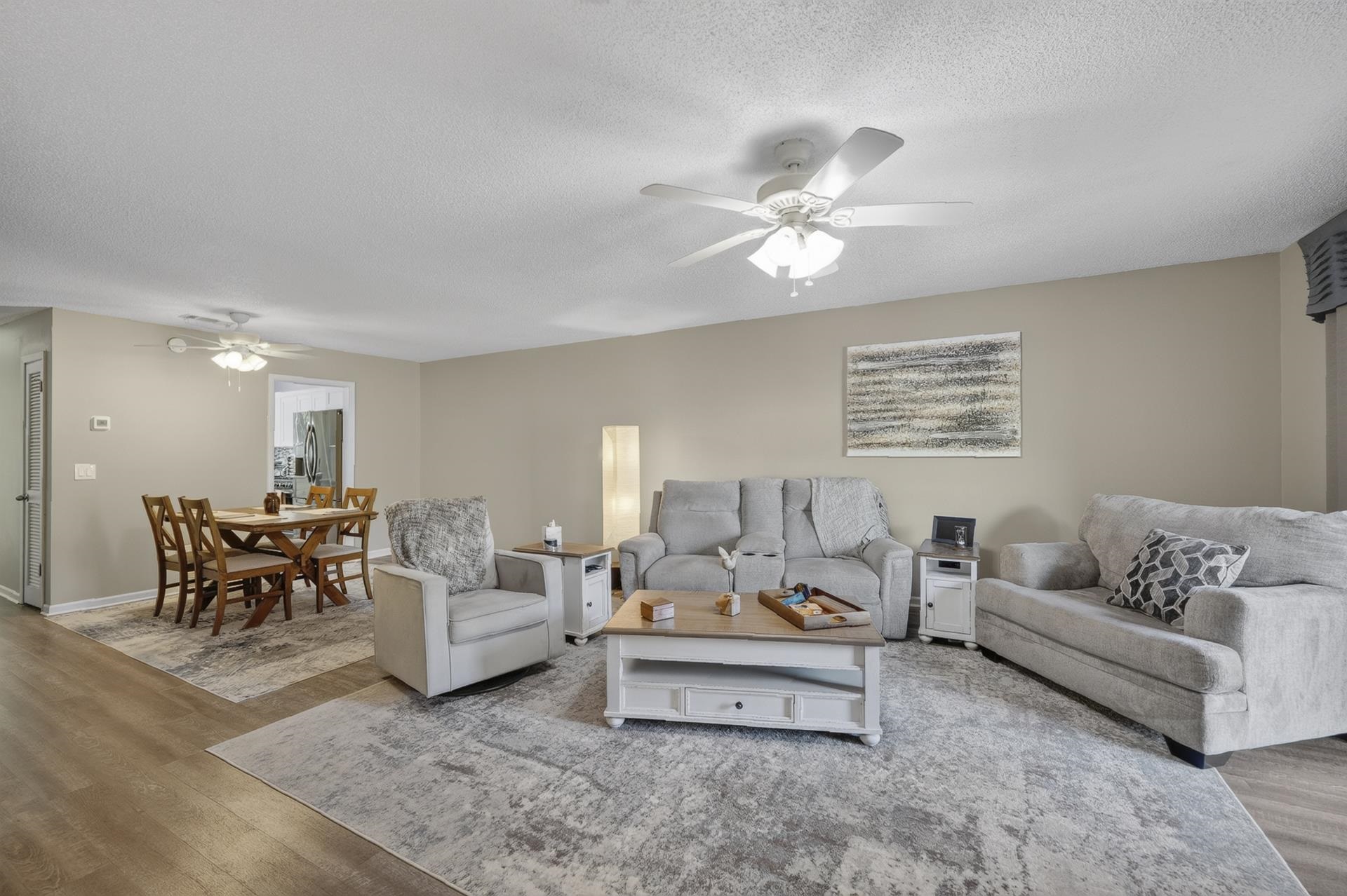 74 Driftwood Road Counce, TN 38326 - Photo 12 of 40 Open-concept living and dining areas featuring wood-finish flooring, neutral wall tones, and ceiling fans for comfort