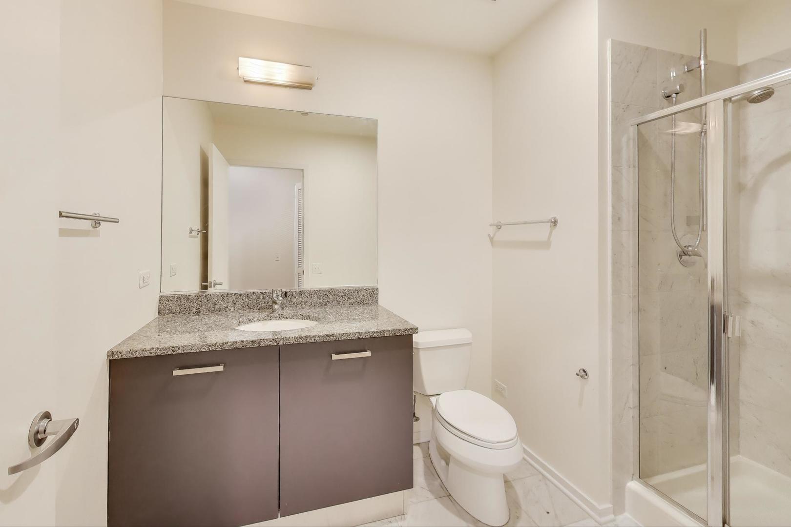 65 East Monroe Street, Unit 4405 Chicago, IL 60603 - Photo 12 of 27 a bathroom with a granite countertop sink toilet and mirror