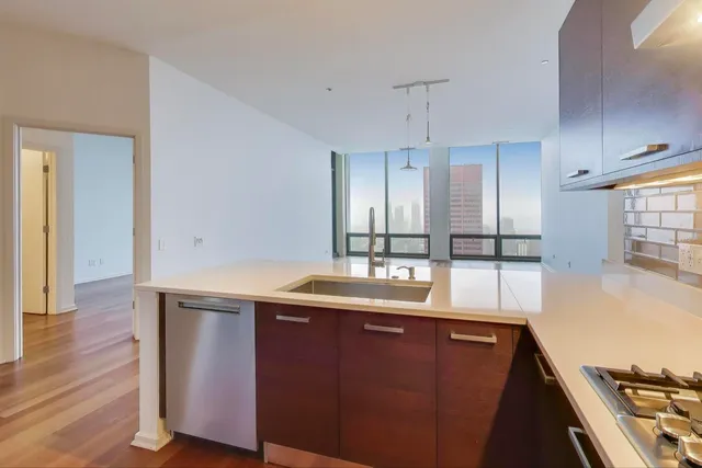 a kitchen with stainless steel appliances granite countertop a sink a stove and a wooden floors