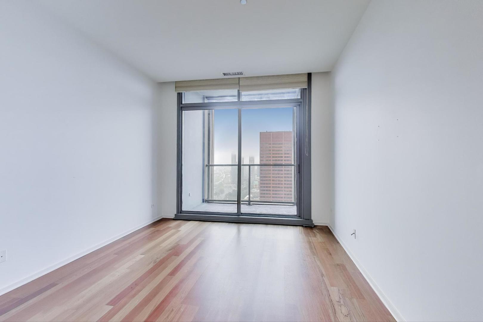 65 East Monroe Street, Unit 4405 Chicago, IL 60603 - Photo 8 of 27 an empty room with wooden floor and windows