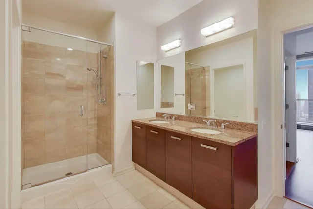 a bathroom with a granite countertop sink mirror and shower