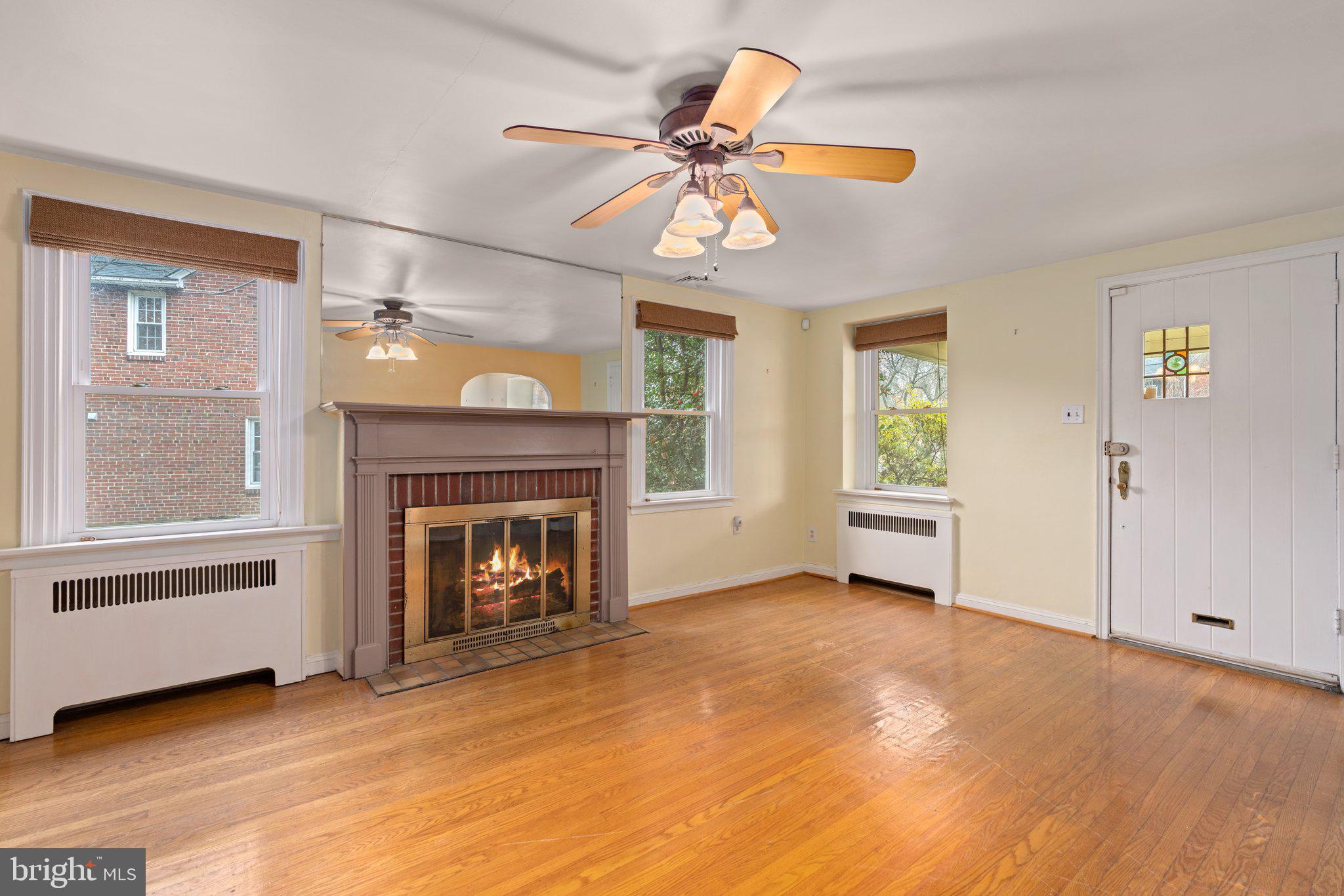 443 Old Farm Road Wyncote, PA 19095 - Photo 9 of 35 a view of a livingroom with a fireplace a ceiling fan and wooden floor