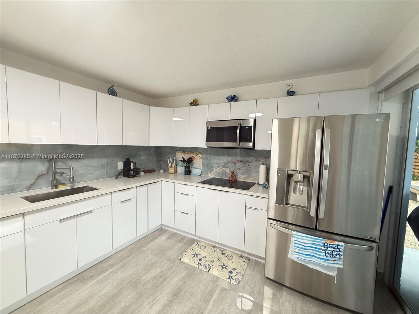 60 Southeast Marlin Avenue, Unit 2 Key Largo, FL 33037 - Photo 6 of 26 a kitchen with stainless steel appliances granite countertop a refrigerator sink and stove