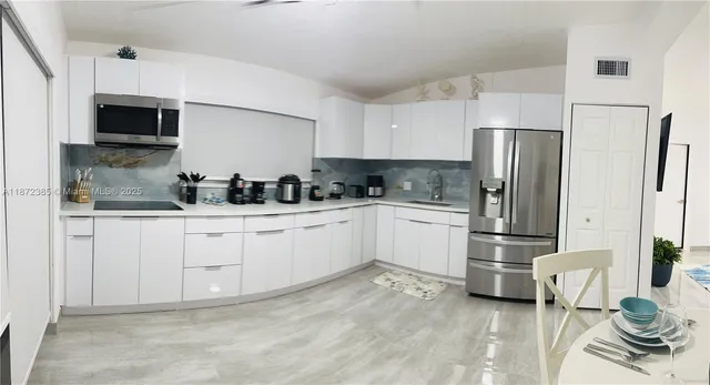a kitchen with stainless steel appliances a refrigerator sink and microwave