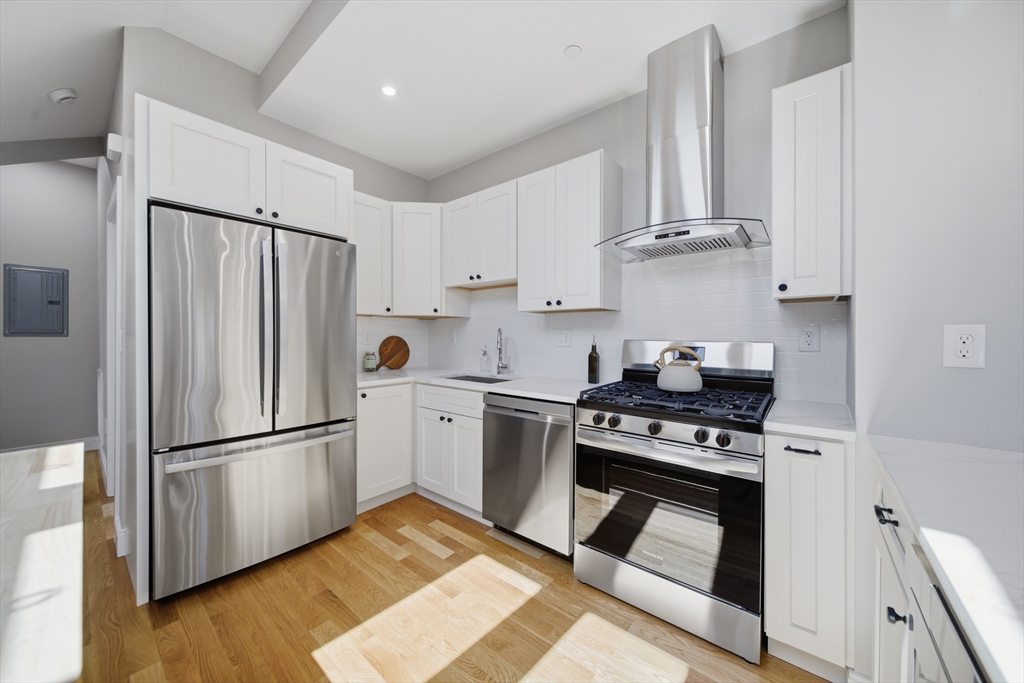 174 Walnut Street, Unit 3 Somerville, MA 02145 - Photo 9 of 38 a kitchen with white cabinets and stainless steel appliances