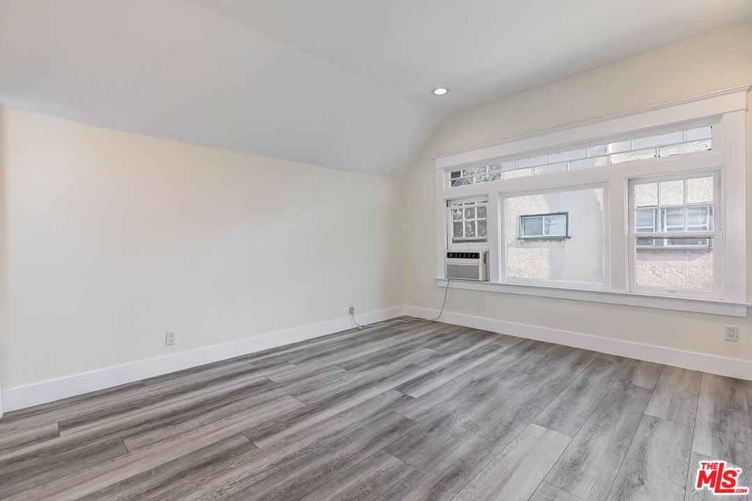 1054 Maine Avenue, Unit 2 Long Beach, CA 90813 - Photo 13 of 21 a view of an empty room with wooden floor and a window