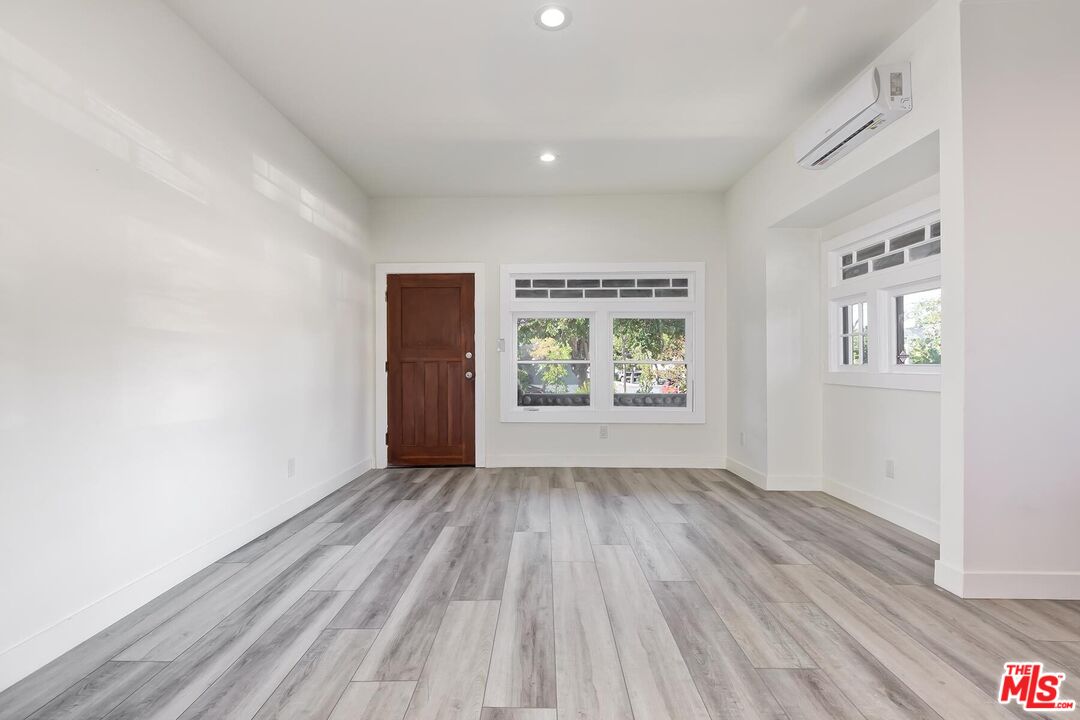 1054 Maine Avenue, Unit 2 Long Beach, CA 90813 - Photo 9 of 21 an empty room with wooden floor and windows