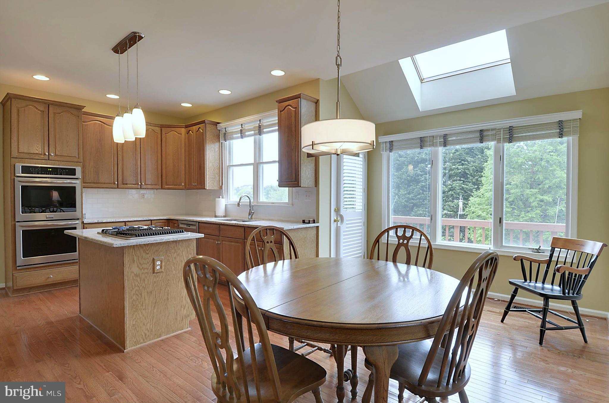 1327 Dasher Lane Reston, VA 20190 - Photo 4 of 30 a kitchen with stainless steel appliances granite countertop a stove a refrigerator a kitchen island a table and chairs