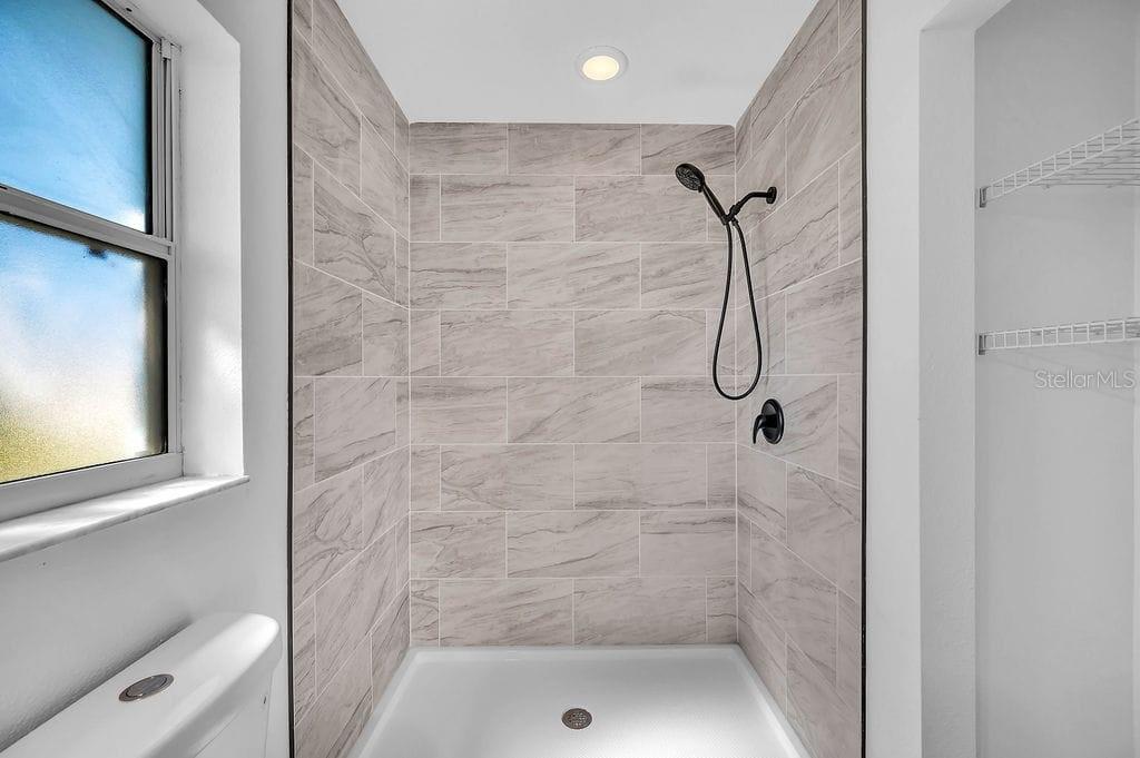 8695 Southwest 60th Circle Ocala, FL 34476 - Photo 17 of 19 a bathroom with a glass shower door