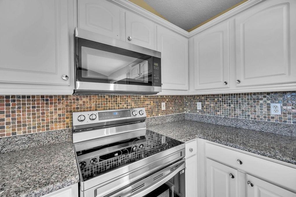 8695 Southwest 60th Circle Ocala, FL 34476 - Photo 4 of 19 a kitchen with granite countertop a stove and a sink