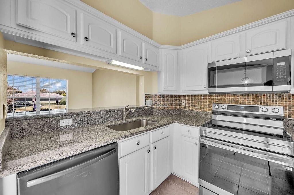 8695 Southwest 60th Circle Ocala, FL 34476 - Photo 5 of 19 a kitchen with granite countertop a sink and cabinets