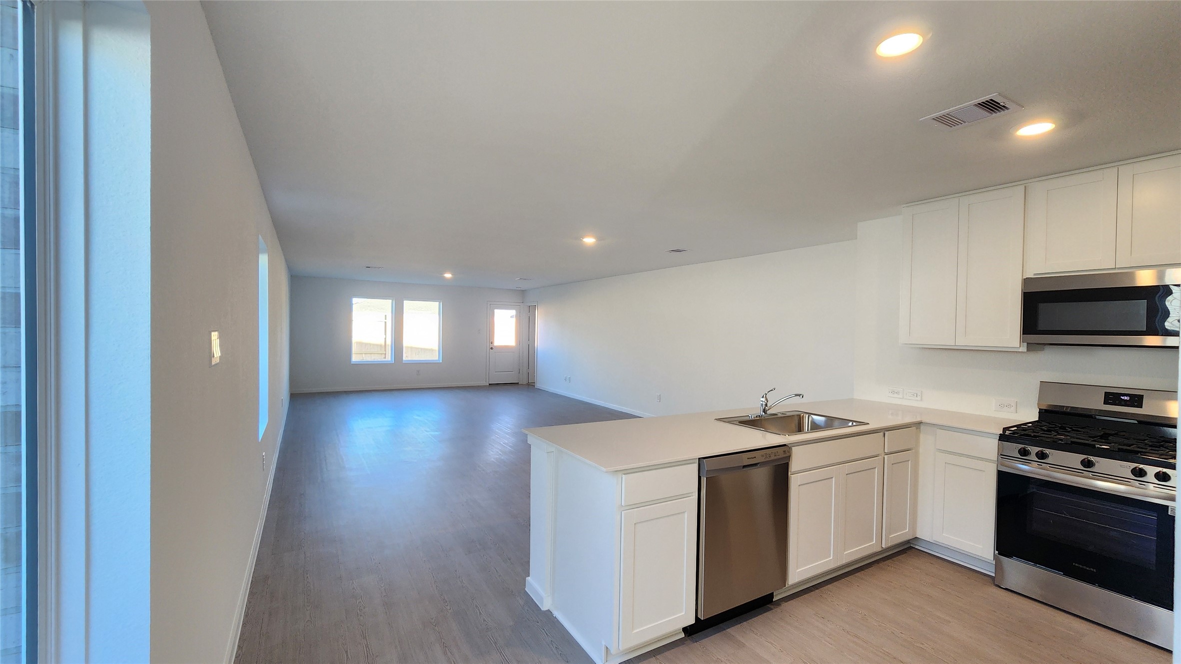 16210 Rustic Prairie Drive Hockley, TX 77447 - Photo 8 of 40 a view of a kitchen with a stove wooden floor and a window