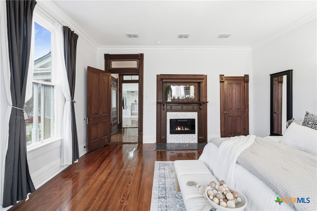 300 Estelle Rice Street Moody, TX 76557 - Photo 33 of 48 a bedroom with a bed wooden floor and a fireplace