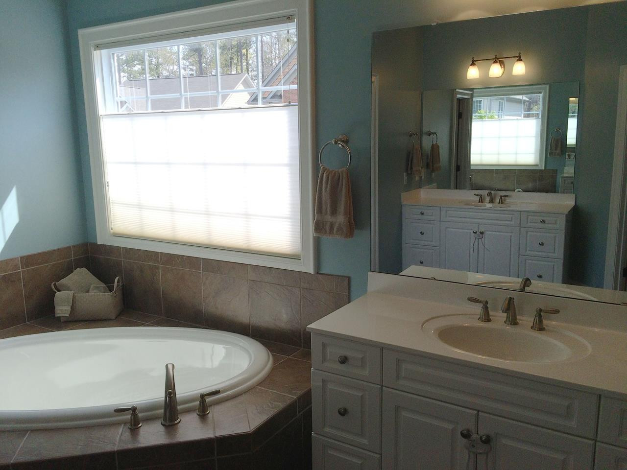 2 Hidden Ridge Court Durham, NC 27707 - Photo 13 of 25 Lovely appointments in this large owner's bathroom: tile flooring, garden tub with large window above, two vanities with sinks, private lavatory. Enormous walk-in closet accessed from this room. Owners' Bathroom - Sinks and tub