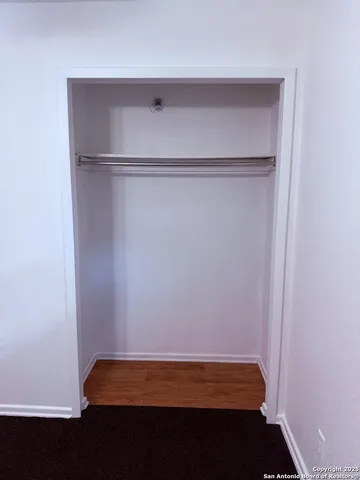 an empty room with a ceiling fan and a window