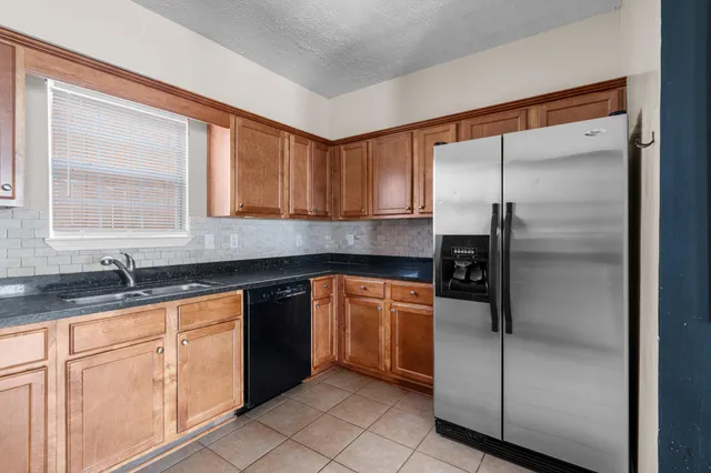 a kitchen with stainless steel appliances granite countertop a refrigerator and a sink