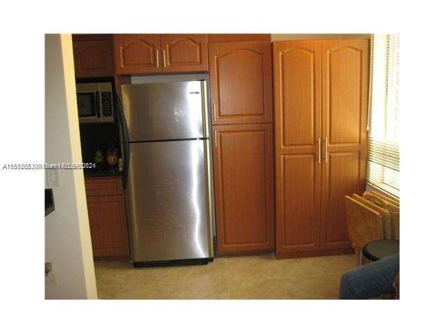 a kitchen with stainless steel appliances a refrigerator and a cabinets