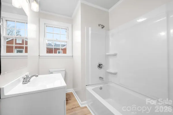 a bathroom with a tub sink and mirror