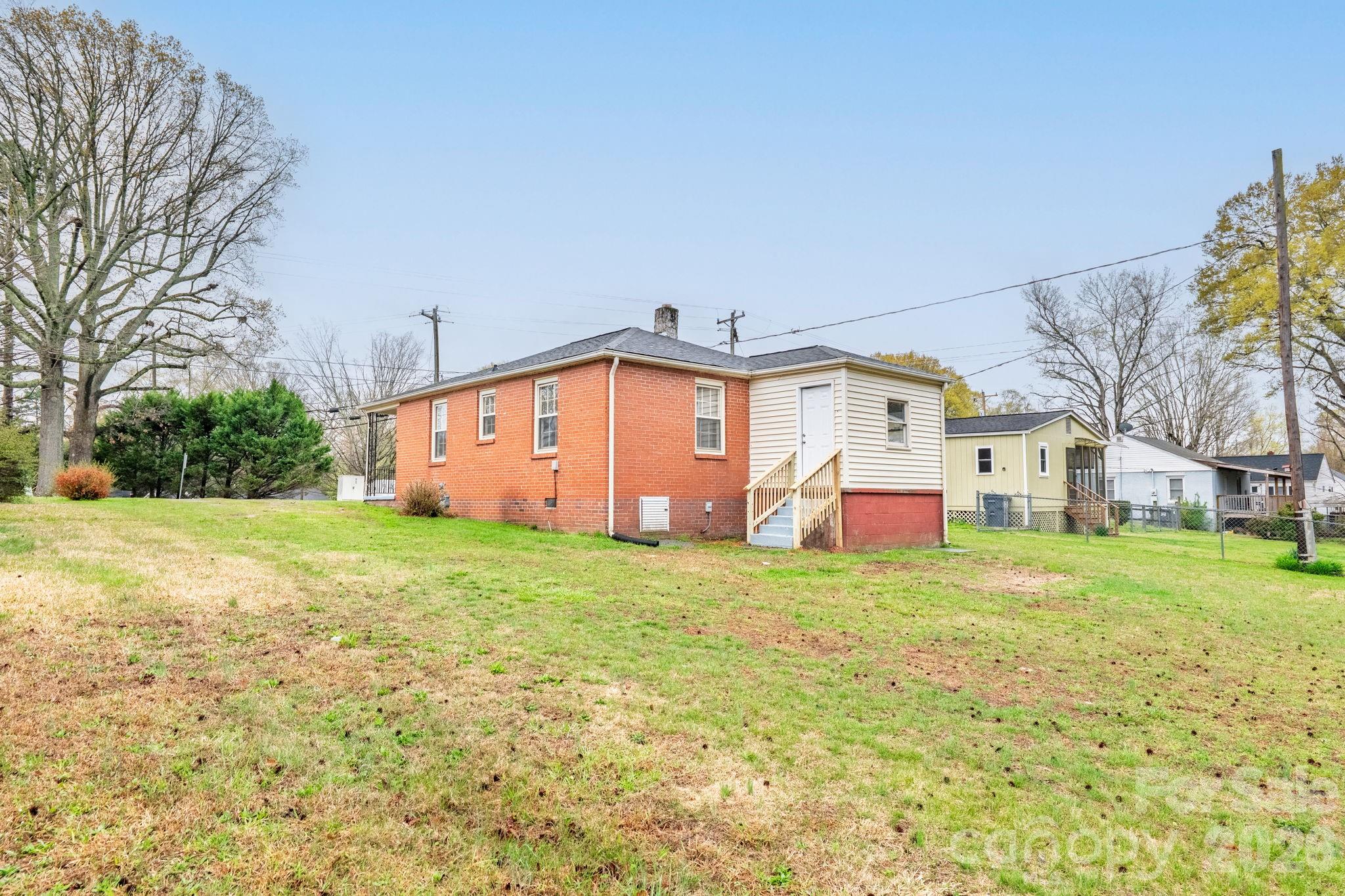 414 Ridge Street Stanley, NC 28164 - Photo 22 of 33 a backyard of a house with wooden fence and large trees