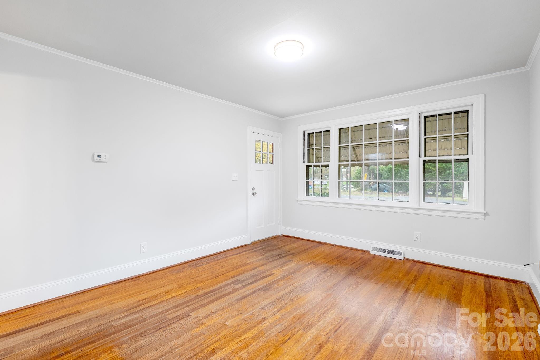 414 Ridge Street Stanley, NC 28164 - Photo 7 of 33 an empty room with wooden floor and windows