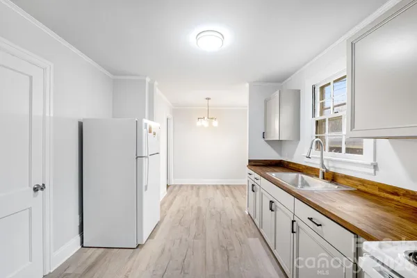 a large kitchen with a sink and a refrigerator