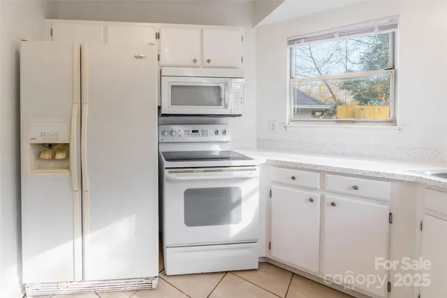 a kitchen with white cabinets and white appliances