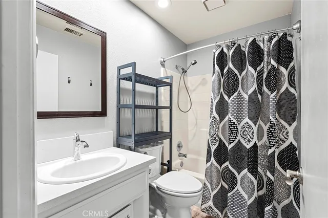 a bathroom with a sink and mirror with toilet