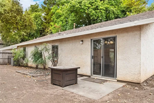 a backyard of a house with large tree and wooden fence